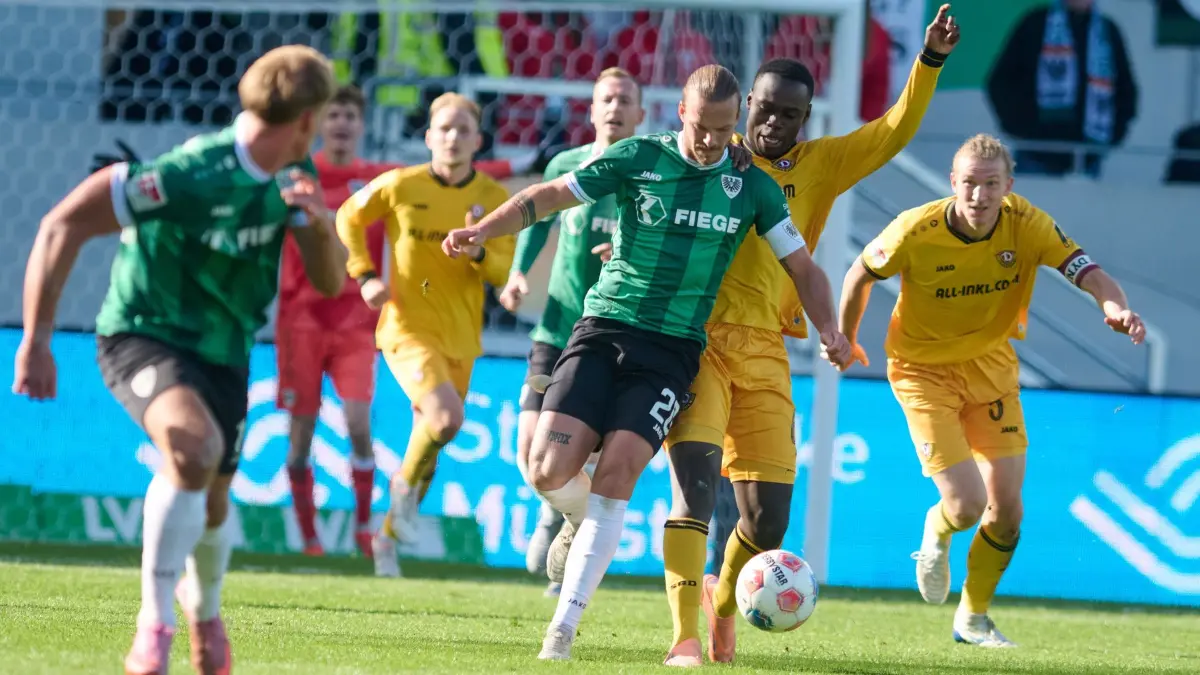 Preußen Münster - Dynamo Dresden: 18.10.2025, Nordrhein-Westfalen, Münster: Fußball: 2. Bundesliga, Preußen Münster - Dynamo Dresden, 9. Spieltag, Preußenstadion. Jorrit Hendrix (Preußen Münster) und Kofi Amoako (Dynamo Dresden) in Aktion. Foto: Bernd Thissen/dpa - WICHTIGER HINWEIS: Gemäß den Vorgaben der DFL Deutsche Fußball Liga bzw. des DFB Deutscher Fußball-Bund ist es untersagt, in dem Stadion und/oder vom Spiel angefertigte Fotoaufnahmen in Form von Sequenzbildern und/oder videoähnlichen Fotostrecken zu verwerten bzw. verwerten zu lassen. +++ dpa-Bildfunk +++