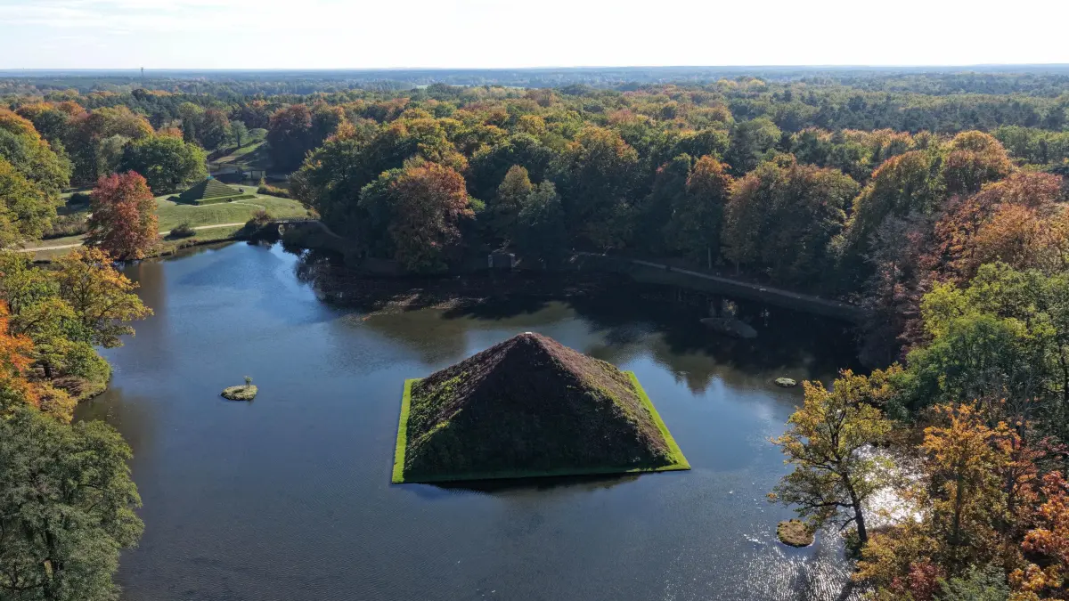 Luft Park Branitz Herbst 2025: Luftaufnahme vom 20. Oktober 2025
Farbenrausch im Branitzer Park
Die Bäume im Branitzer Park des von Fürst Pückler geschaffenen Parkensembles sind derzeit herbstlich gefärbt und sorgen für einen Farbenrausch. Bei einem herbstlichen Spaziergang ist die herbstlich eingefärbte rund 13 Meter hohe Pyramide als Wahrzeichen der vom Landschaftsarchitekten Hermann Fürst von Pückler-Muskau (1785-1871) geschaffenen Parkanlage immer wieder ein schöner Blickfang. Sie wurde 1856 binnen weniger Monate auf einer ebenen grünen Wiese aufgeschüttet und 1863 mit der Pflanzung des wilden Weins fertiggestellt. Seit 1871 ist die Seepyramide Grabstätte des Fürsten. 1884 wurde Fürstin Lucie von Pückler-Muskau (1776-1854) vom alten Branitzer Dorffriedhof in die Pyramide umgebettet. Beide liegen in einem nunmehr mit Erde gefüllten Stollen auf der Nordostseite der Pyramide. Die im See gelegene Pyramide ist zu jeder Jahreszeit ein Blickfang.