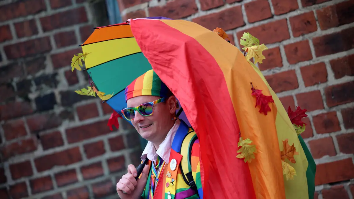 Christopher Street Day In Cottbus: Christopher Street Day In Cottbus A participant takes part in the 17th Christopher Street Day CSD parade in Cottbus, Germany, with the motto United in Peace and Diversity. Police escort the demonstration with reinforced units and estimate more than 800 participants, while around 90 right-wing counter-protesters gather nearby. Two individuals are removed for allegedly inciting criminal acts, and one dispersal order is issued. After several rainbow flags are vandalized the night before, organizers increase security and steward numbers, as a home match of Energie Cottbus takes place simultaneously in the city. Cottbus Germany PUBLICATIONxNOTxINxFRA Copyright: xRouzbehxFouladix originalFilename: fouladi-christop251025_npoEy.jpg