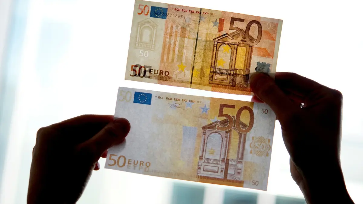 Falschgeld: ARCHIV - 31.03.2011, NA, Berlin: Ein echter und ein falscher Fünfzig-Euro-Schein werden gegen das Licht gehalten. (zu dpa: «Falschgeld im Kinderzimmer gedruckt? Polizei ermittelt») Foto: Franziska Gabbert/dpa-Zentralbild/dpa +++ dpa-Bildfunk +++
