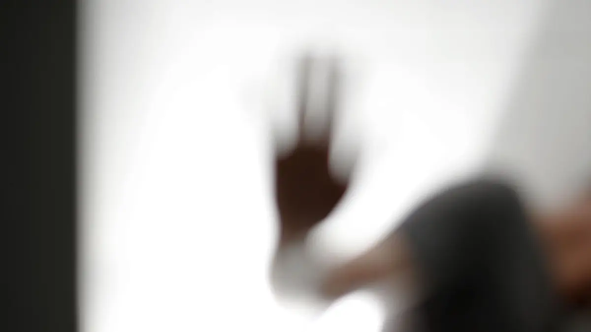 ILLUSTRATION - 25.01.2015, Baden-Württemberg, Ravensburg: Ein Mann steht hinter einer Glaswand, auf die er eine Hand legt. (zu dpa: «Studie: Immer mehr junge Menschen im Südwesten psychisch krank» vom 04.06.2018) Foto: Felix Kästle/dpa +++ dpa-Bildfunk +++