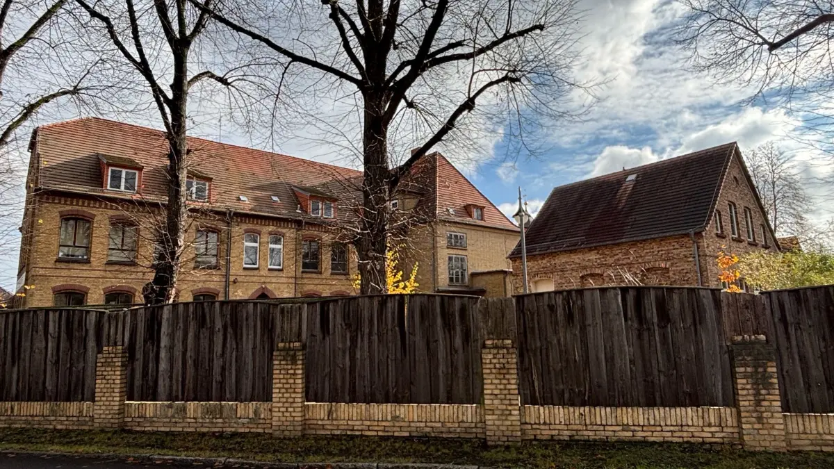 Bereits seit vielen Jahren umgibt dieser Bretterzaun den einstigen Schulhof. Erhalten wurden die alten Linden.
