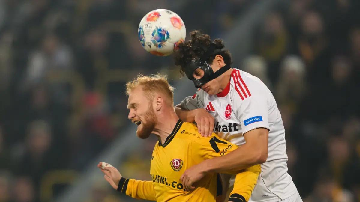 SG Dynamo Dresden - 1. FC Nürnberg: 07.11.2025, Sachsen, Dresden: Fußball: 2. Bundesliga, SG Dynamo Dresden - 1. FC Nürnberg, 12. Spieltag, Rudolf-Harbig-Stadion, Nils Fröling (l, Dynamo Dresden,) in Aktion gegen Fabio Gruber (1.FC Nürnberg). Foto: Robert Michael/dpa - WICHTIGER HINWEIS: Gemäß den Vorgaben der DFL Deutsche Fußball Liga bzw. des DFB Deutscher Fußball-Bund ist es untersagt, in dem Stadion und/oder vom Spiel angefertigte Fotoaufnahmen in Form von Sequenzbildern und/oder videoähnlichen Fotostrecken zu verwerten bzw. verwerten zu lassen. +++ dpa-Bildfunk +++