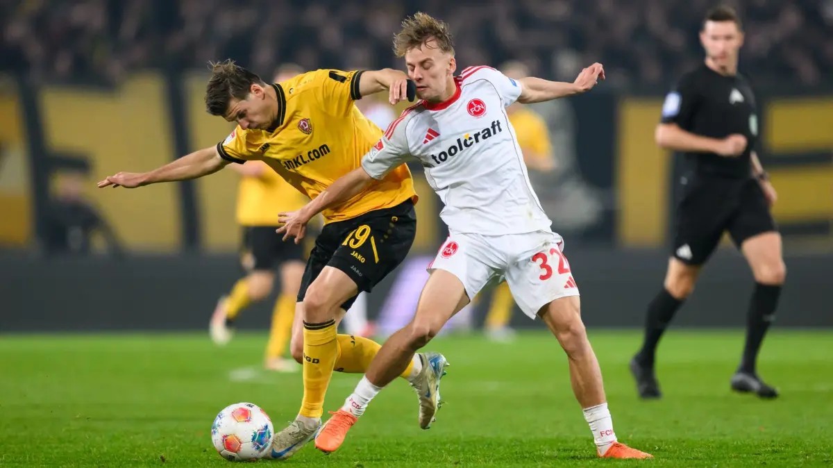 SG Dynamo Dresden - 1. FC Nürnberg: 07.11.2025, Sachsen, Dresden: Fußball: 2. Bundesliga, SG Dynamo Dresden - 1. FC Nürnberg, 12. Spieltag, Rudolf-Harbig-Stadion, Alexander Rossipal (l, Dynamo Dresden) in Aktion gegen Tim Janisch (1. FC Nürnberg). Foto: Robert Michael/dpa - WICHTIGER HINWEIS: Gemäß den Vorgaben der DFL Deutsche Fußball Liga bzw. des DFB Deutscher Fußball-Bund ist es untersagt, in dem Stadion und/oder vom Spiel angefertigte Fotoaufnahmen in Form von Sequenzbildern und/oder videoähnlichen Fotostrecken zu verwerten bzw. verwerten zu lassen. +++ dpa-Bildfunk +++