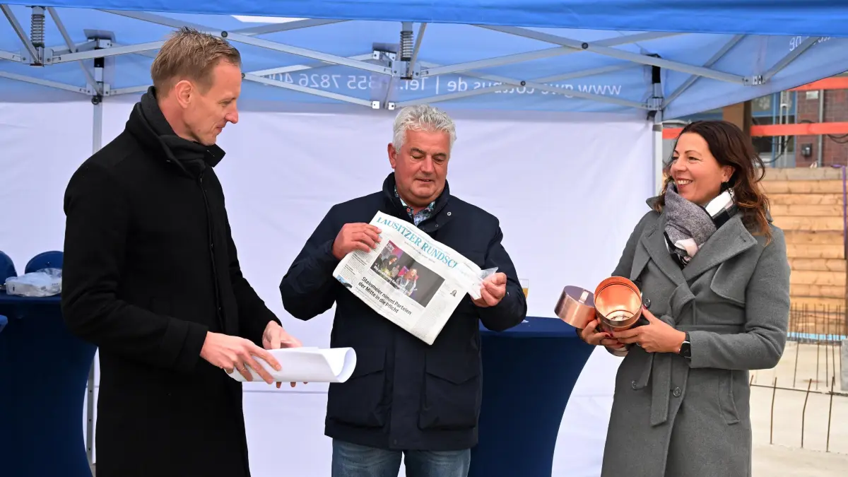 Grundstein 2. BA GWC Briesmannstr: Für den 2. Bauabschnitt des Wohnungsbauprojektes der Gebäudewirtschaft Cottbus GmbH (GWC) in der Briesmannstrasse ist am Montag (10. November 2025) der Grundstein gelegt worden. Hier entstehen noch einmal 50 Wohnungen
GWC-Geschäftsführer Dr. Sebastian Herke (l.), Generalauftragnehmer Jörg Schnapke (Sternbau GmbH) und Bürgermeisterin Doreen Mohaupt befüllten die Schatulle mit zeitgenössischen Dokumenten und den Bauplänen und versenkten ihn in der Bodenplatte.