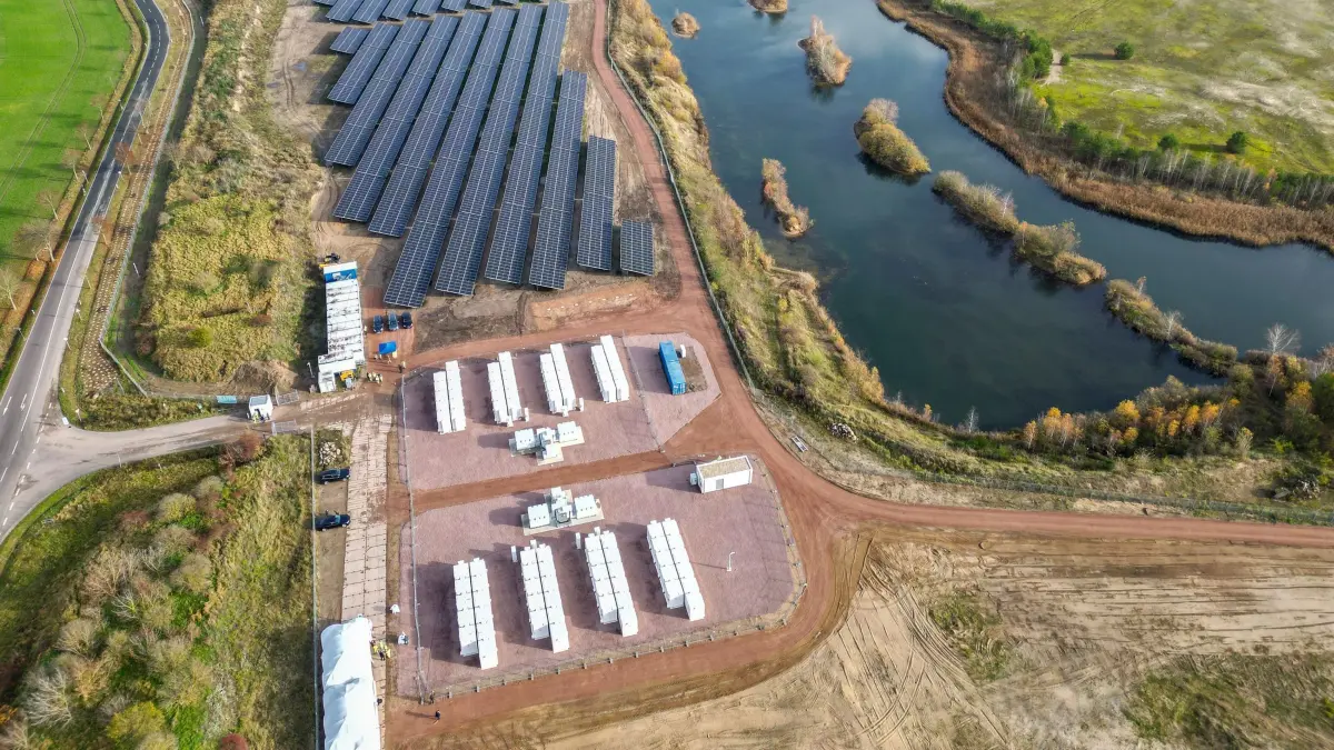 Neues Solar-Batteriespeicher-Hybridkraftwerk in Sachsen-Anhalt: 12.11.2025, Sachsen-Anhalt, Zerbst: 88 Batteriespeicher stehen im neuen PV-Batteriespeicher-Hybridkraftwerk auf dem Gelände einer ehemaligen Kiesgrube. Der norwegische Energiekonzern Statkraft errichtete mit einem 46,4-MW-Solarpark und 16-MW-Batteriespeicher hier die erste eigenentwickelte Erneuerbare-Energien-Anlage und gleichzeitig bundesweit das größte Kraftwerk. Der Solarpark versorgt ca. 14.000 Haushalte mit grüner Energie, während der Batteriespeicher den lokal erzeugten Solarstrom bedarfsgerecht ins Stromnetz einspeist. (Luftaufnahme mit Drohne) Foto: Jan Woitas/dpa +++ dpa-Bildfunk +++