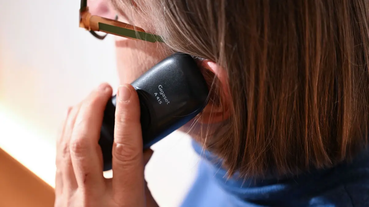 Schockanruf: ILLUSTRATION - 07.11.2025, Baden-Württemberg, Stuttgart: Eine Frau hält ein Festnetz-Telefon ans Ohr (gestellte Szene). (zu dpa: «Einsatz gegen «Enkeltrick»-Betrüger - 16 Festnahmen») Foto: Bernd Weißbrod/dpa +++ dpa-Bildfunk +++