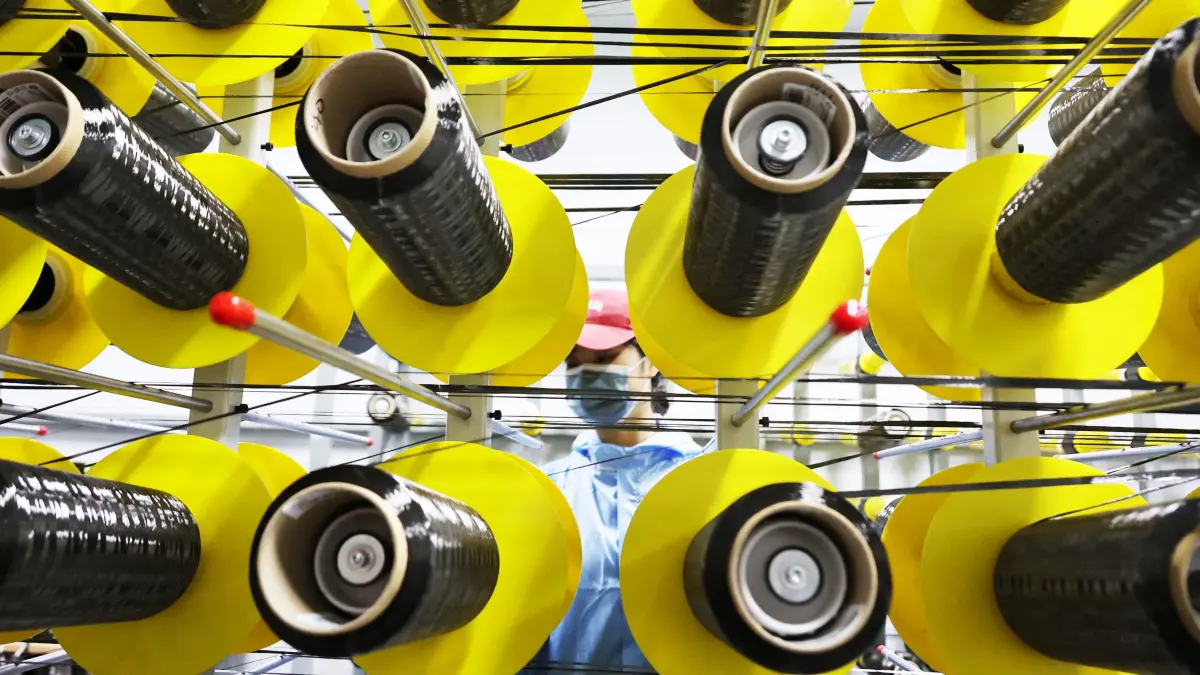 A worker checks carbon fibre in production line at a bicycle factory in Lianyungang, eastern China's Jiangsu province on November 14, 2025. (Photo by AFP) / China OUT