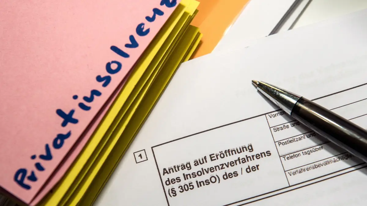 Überschuldung und Privatinsolvenz: ARCHIV - 07.11.2015, Berlin: ILLUSTRATION - Das Wort «Privatinsolvenz» steht auf einem Trennblatt, während davor ein Antrag zur Eröfnung eines Insolvenzverfahrens liegt. Die Unternehmensgruppe Creditreform gibt am 14.11.2019 eine Pk in Düsseldorf zum Schuldneratlas 2019. (zu dpa: «Schuldneratlas: Saarland über dem Bundesdurchschnitt») Foto: Alexander Heinl/dpa +++ dpa-Bildfunk +++