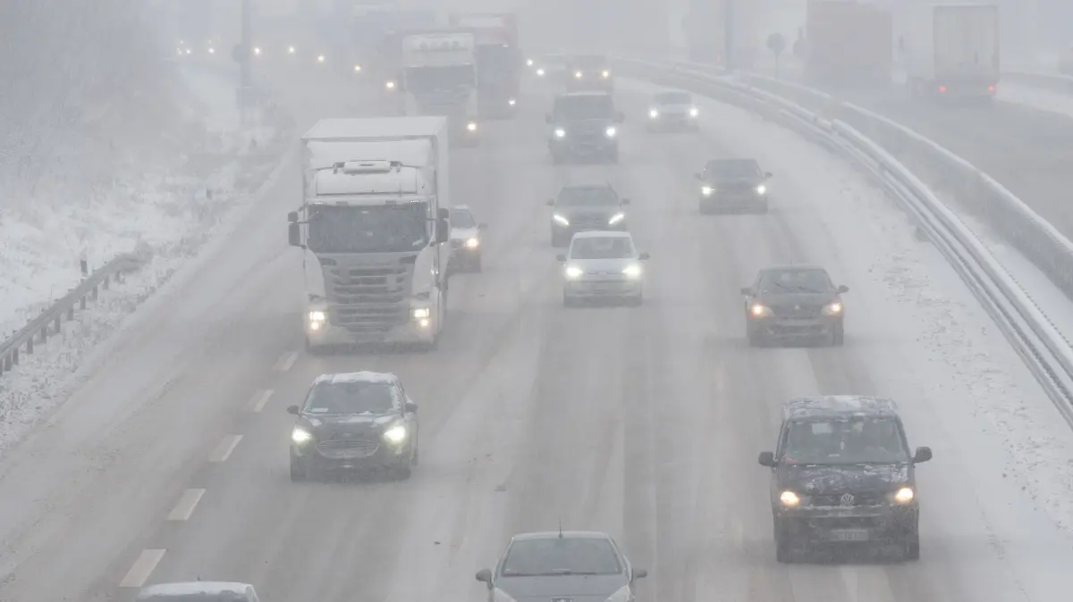 Autos und LKW fahren auf der Autobahn 4 am Autobahndreieck Dresden-Nord im dichten Schneetreiben. +++ dpa-Bildfunk +++