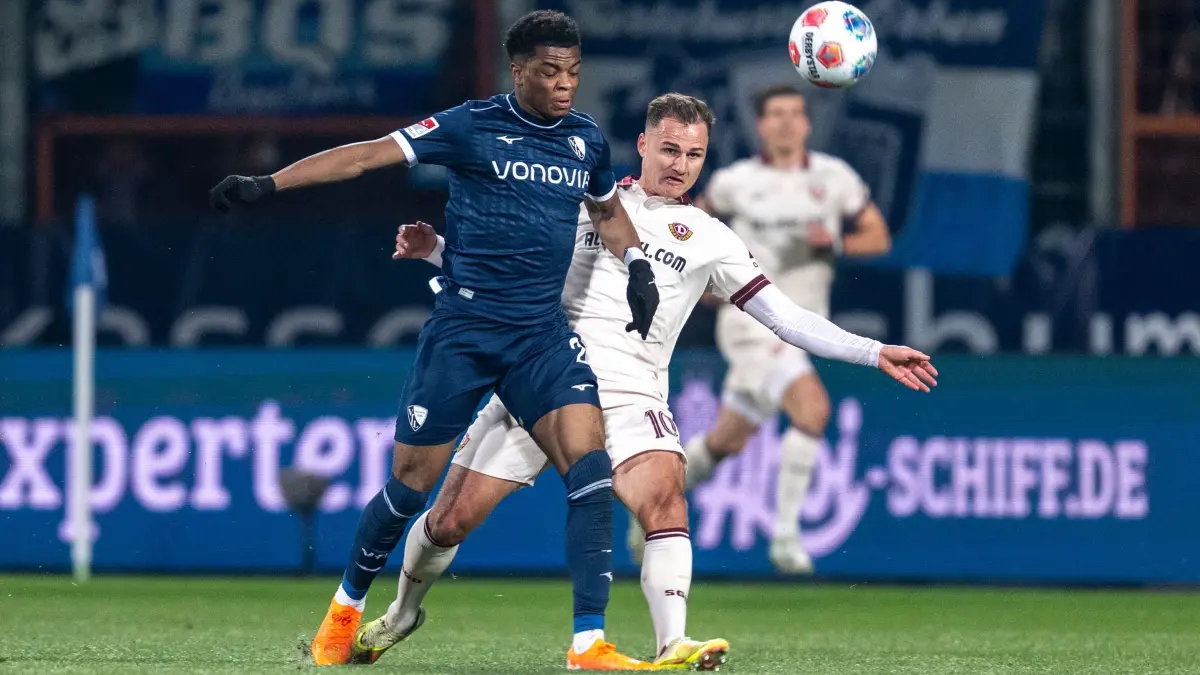 VfL Bochum - Dynamo Dresden: 21.11.2025, Nordrhein-Westfalen, Bochum: Fußball: 2. Bundesliga, VfL Bochum - Dynamo Dresden, 13. Spieltag, Vonovia Ruhrstadion: Farid Alfa-Ruprecht (VfL Bochum) (l) und Jakob Lemmer (Dynamo Dresden) kämpfen um den Ball. Foto: David Inderlied/dpa - WICHTIGER HINWEIS: Gemäß den Vorgaben der DFL Deutsche Fußball Liga bzw. des DFB Deutscher Fußball-Bund ist es untersagt, in dem Stadion und/oder vom Spiel angefertigte Fotoaufnahmen in Form von Sequenzbildern und/oder videoähnlichen Fotostrecken zu verwerten bzw. verwerten zu lassen. +++ dpa-Bildfunk +++