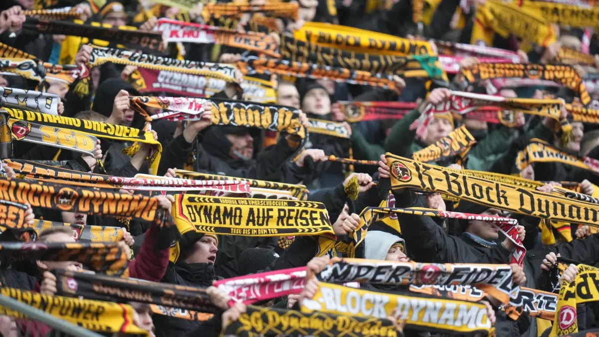 1. FC Kaiserslautern - Dynamo Dresden: 06.12.2025, Rheinland-Pfalz, Kaiserslautern: Fußball: 2. Bundesliga, 1. FC Kaiserslautern - Dynamo Dresden, 15. Spieltag, Fritz-Walter-Stadion. Dresdens Fans halten ihre Fanschals hoch. Foto: Thomas Frey/dpa - WICHTIGER HINWEIS: Gemäß den Vorgaben der DFL Deutsche Fußball Liga bzw. des DFB Deutscher Fußball-Bund ist es untersagt, in dem Stadion und/oder vom Spiel angefertigte Fotoaufnahmen in Form von Sequenzbildern und/oder videoähnlichen Fotostrecken zu verwerten bzw. verwerten zu lassen. +++ dpa-Bildfunk +++