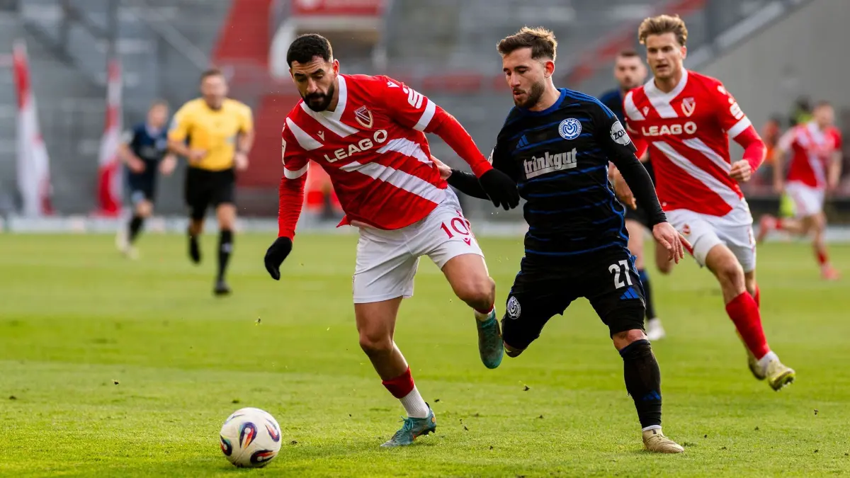 Energie Cottbus - MSV Duisburg: 06.12.2025, Brandenburg, Cottbus: Fußball: 3. Liga, Energie Cottbus - MSV Duisburg, 17. Spieltag, LEAG Energie Stadion. Tolcay Cigerci (l, Energie Cottbus) im Zweikampf mit Can Coskun (MSV Duisburg). Foto: Julius Frick/dpa +++ dpa-Bildfunk +++