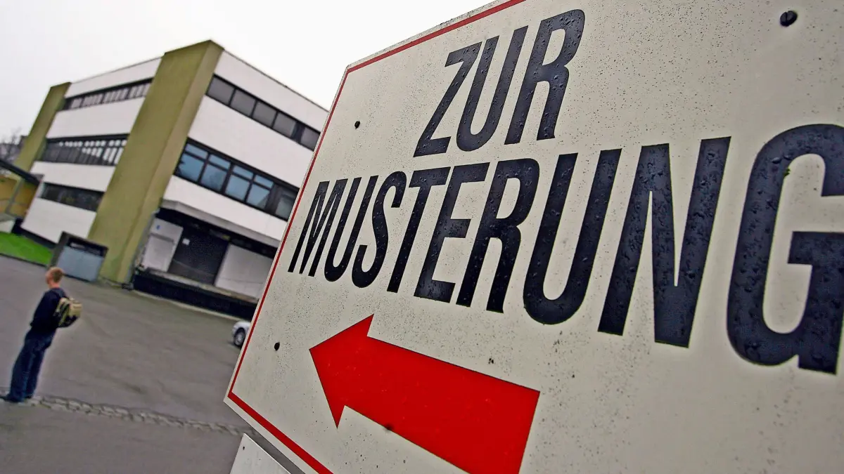 ARCHIV - 03.04.2007, Bayern, Kempten: Ein Wehrpflichtiger steht am 04.04.2007 unter einem Hinweisschild mit der Aufschrift «Zur Musterung» vor dem Kreiswehrersatzamt in Kempten (Schwaben). (zu dpa: «Schülerstreik gegen neues Wehrdienstgesetz») Foto: Karl-Josef Hildenbrand/dpa +++ dpa-Bildfunk +++