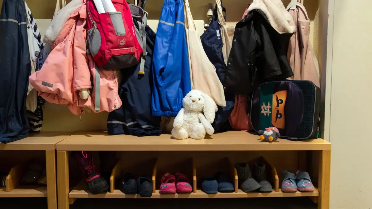 Kindertagesstätte: ARCHIV - 26.01.2022, Nordrhein-Westfalen, Bielefeld: In der Garderobe in einer Kindertagesstätte (Kita) hängen Kinderjacken. (zu dpa: «Kernzeiten und mehr Geld – Gesetz zur Kita-Reform liegt vor») Foto: Friso Gentsch/dpa +++ dpa-Bildfunk +++
