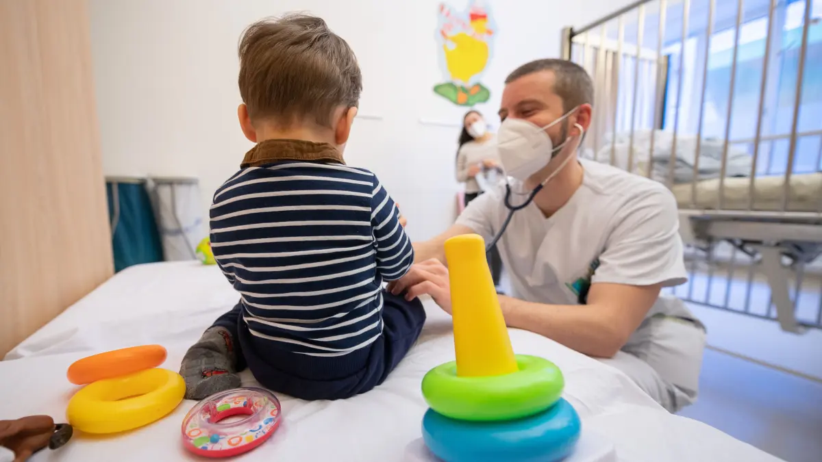 Ein Arzt untersucht in einer Kinderklinik ein Kind.