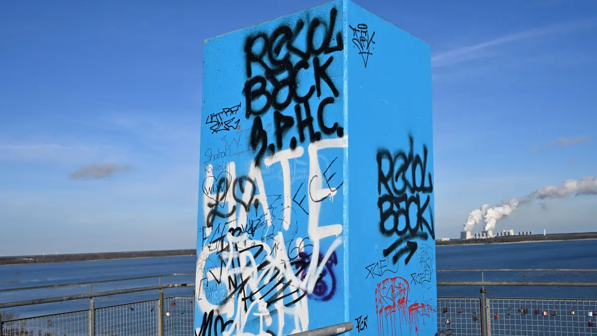 Ostsee Aussichts Merzdorf Graffiti Dez 2025: Der vom Cottbuser Graffiti-Künstler Marcus Preuß vom Studio 26 im Auftrag der LEAG im April 2024 neu gestaltete Aussichtsturm Merzdorf am Cottbuser Ostsee ist inzwischen mit vielen hässlichen Graffitis von sogenannten Fußballfans des FC Energie Cottbus verunstaltet worden.