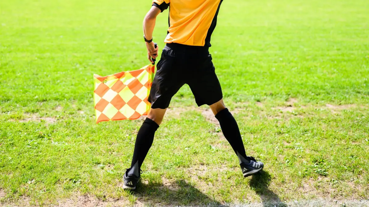 Amateuerfussball: PRODUKTION - 10.08.2025, Niedersachsen, Hannover: Ein junger Schiedsrichter steht als Linienrichter auf einem Amateurfußballplatz in der Region Hannover. (zu dpa: «Fußballfan versetzt Torschützen Kopfstoß und verletzt ihn») Foto: Julian Stratenschulte/dpa +++ dpa-Bildfunk +++