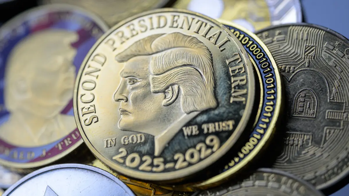 A Donald Trump coin is pictured alongside Bitcoin and various other cryptocurrencies in this photo illustration in Brussels, Belgium, on August 5, 2025. (Photo by Jonathan Raa/NurPhoto) (Photo by Jonathan Raa / NurPhoto via AFP)