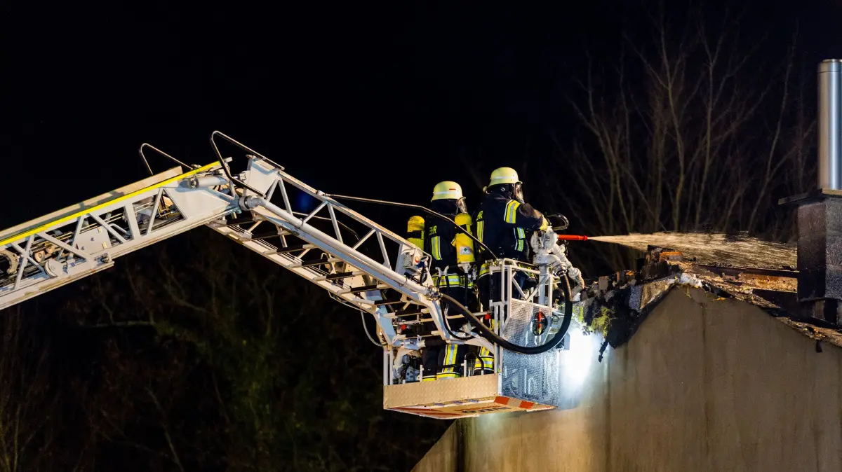 Über einen Hubsteiger haben zwei Feuerwehrleute den Dachstuhlbrand in Guben bekämpft.