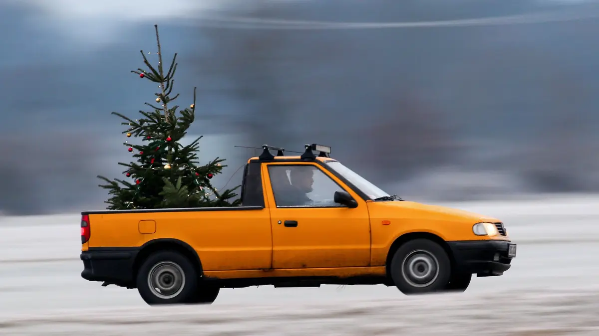 Ein Mann hat auf die Ladefläche seines Pick-ups einen geschmückten Weihnachtsbaum montiert. Er will damit nach eigener Aussage in der Vorweihnachtszeit, die von der Corona-Pandemie geprägt ist, den Leuten ein Lächeln ins Gesicht zaubern. +++ dpa-Bildfunk +++