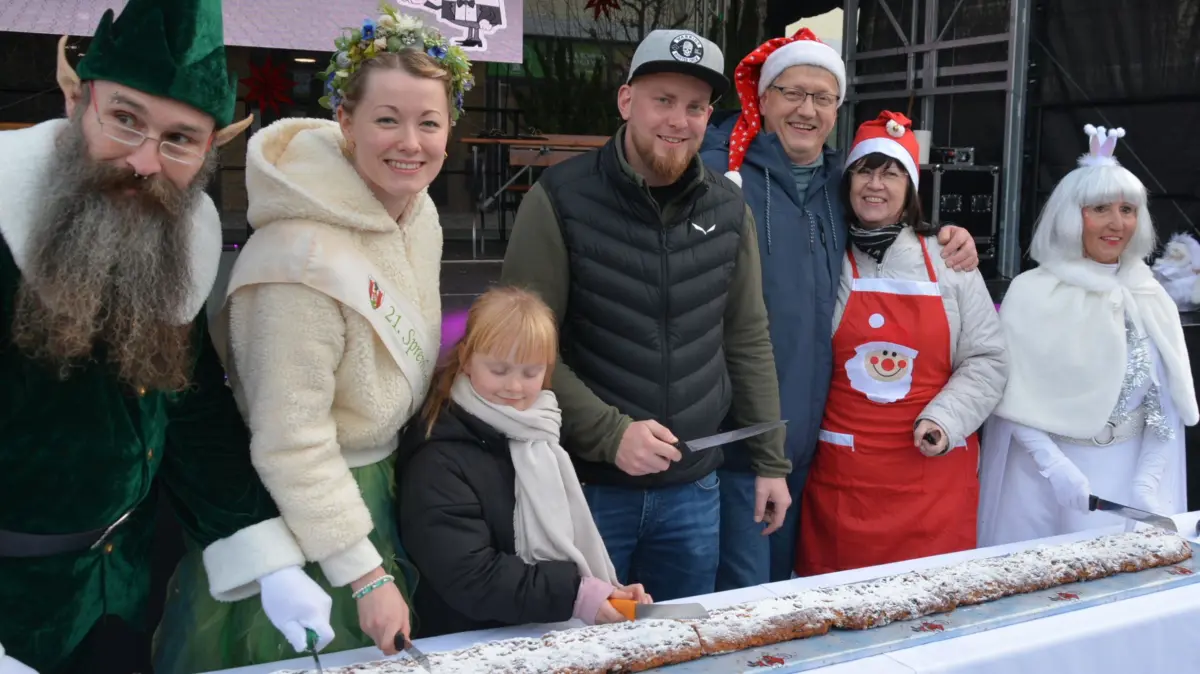 Mit dem Stollenanschnitt wird der Weihnachtsmarkt in Spremberg eröffnet: Beim Schneiden und Verteilen helfen Markus Deeng als Wichtel, Spreenixe Lucy Haschick, Dirk Noack vom Verein Spremberger Land, Bäcker Jörg Eggers, Bürgermeisterin Christine Herntier (parteilos) und Veronika Dubau als Schneefrau.