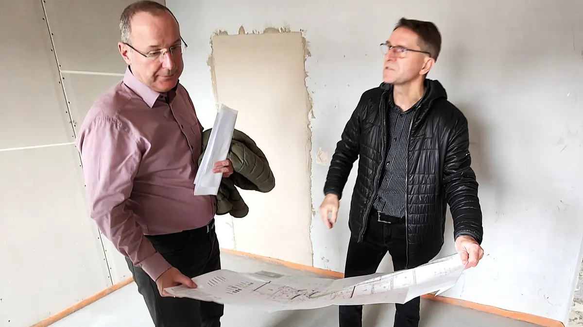 Geschäftsführer Steffen Markgraf (l.) und Projektleiter Waldemar Kampa vergleichen in der Herder-Straße von Hoyerswerda den Stand der Arbeiten mit dem Bauplan.