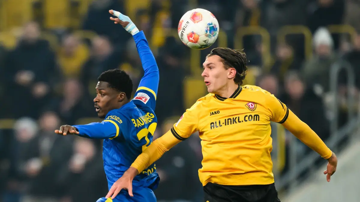 SG Dynamo Dresden - Eintracht Braunschweig: 12.12.2025, Sachsen, Dresden: Fußball: 2. Bundesliga, SG Dynamo Dresden - Eintracht Braunschweig, 16. Spieltag, Rudolf-Harbig-Stadion, Julian Pauli (Dynamo Dresden, r) gegen Christian Conteh (Eintracht Braunschweig). Foto: Robert Michael/dpa - WICHTIGER HINWEIS: Gemäß den Vorgaben der DFL Deutsche Fußball Liga bzw. des DFB Deutscher Fußball-Bund ist es untersagt, in dem Stadion und/oder vom Spiel angefertigte Fotoaufnahmen in Form von Sequenzbildern und/oder videoähnlichen Fotostrecken zu verwerten bzw. verwerten zu lassen. +++ dpa-Bildfunk +++