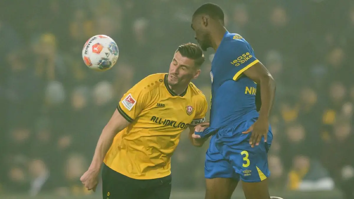 SG Dynamo Dresden - Eintracht Braunschweig: 12.12.2025, Sachsen, Dresden: Fußball: 2. Bundesliga, SG Dynamo Dresden - Eintracht Braunschweig, 16. Spieltag, Rudolf-Harbig-Stadion, Stefan Kutschke (Dynamo Dresden, l) gegen Patrick Nkoa (Eintracht Braunschweig). Foto: Robert Michael/dpa - WICHTIGER HINWEIS: Gemäß den Vorgaben der DFL Deutsche Fußball Liga bzw. des DFB Deutscher Fußball-Bund ist es untersagt, in dem Stadion und/oder vom Spiel angefertigte Fotoaufnahmen in Form von Sequenzbildern und/oder videoähnlichen Fotostrecken zu verwerten bzw. verwerten zu lassen. +++ dpa-Bildfunk +++