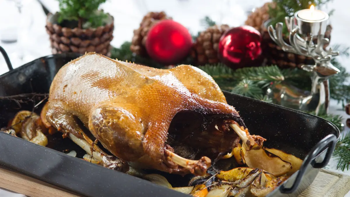 Eine Gänsebraten steht auf einem festlich gedeckten Tisch
