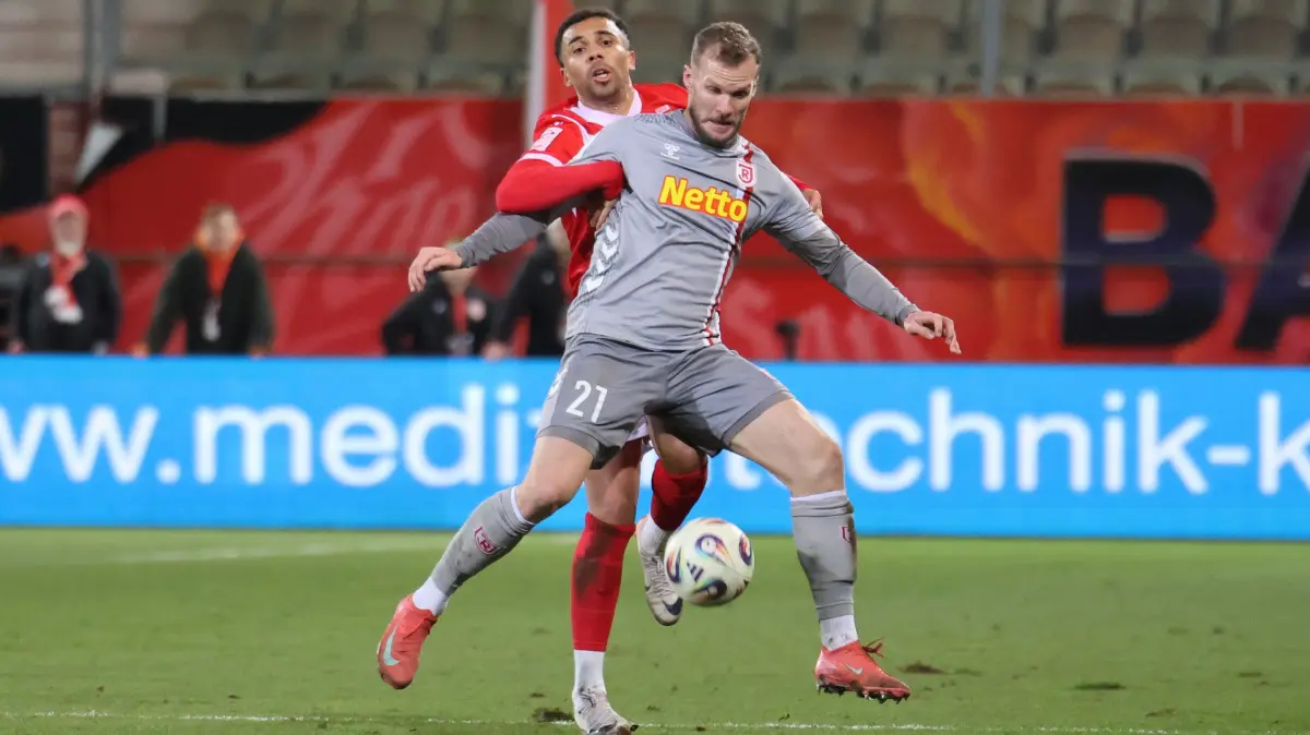 Fussball 3. Liga 2025/2026 FC Energie Cottbus - SSV Jahn Regensburg: 21 Leon Guwara (Energie Cottbus, h.), 21 Eric Hottmann (Regensburg, vorn)