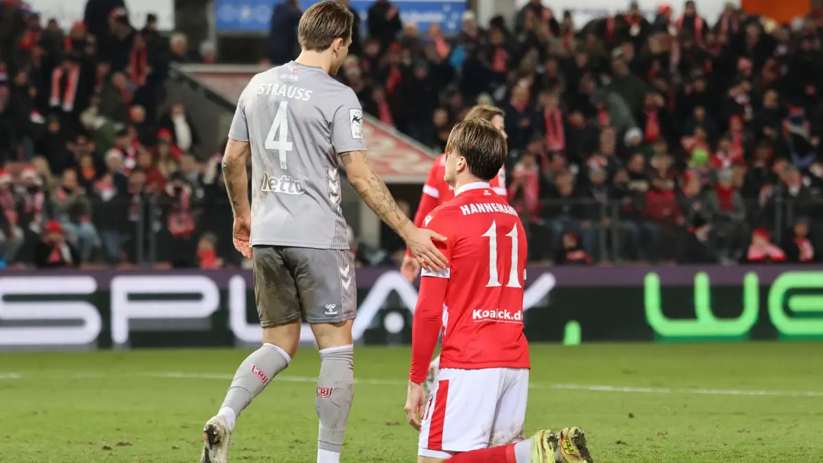 Fussball 3. Liga 2025/2026 FC Energie Cottbus - SSV Jahn Regensburg: 4 Felix Strauss (Regensburg, l.) tröstet 11 Moritz Hannemann (Energie Cottbus) nach seiner vergebenen Chance zum 3-2