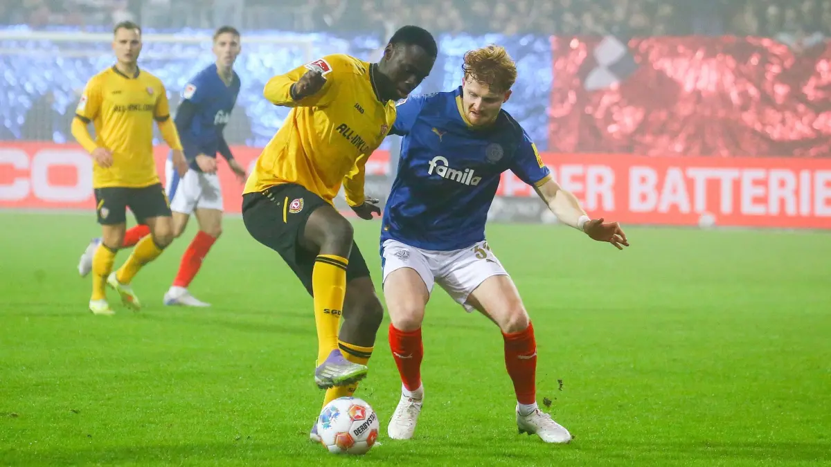 Holstein Kiel - Dynamo Dresden: 20.12.2025, Schleswig-Holstein, Kiel: Fußball: 2. Bundesliga, Holstein Kiel - Dynamo Dresden, 17. Spieltag, Holstein-Stadion Zweikampf zwischen Kofi Amoako (SG Dynamo Dresden) und Robert Wagner (Holstein Kiel) Foto: Michael Hundt/dpa +++ dpa-Bildfunk +++