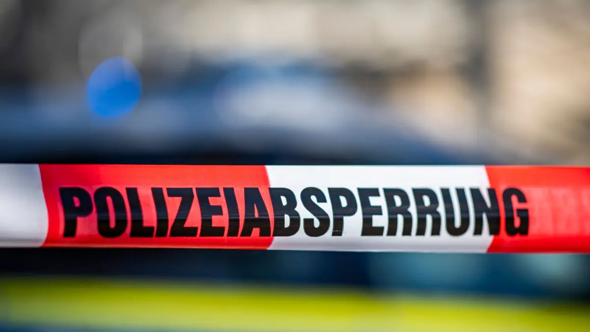 Absperrung der Polizei: ARCHIV - 28.09.2021, Nordrhein-Westfalen, Gütersloh: Ein Absperrband mit der Aufschrift «Polizeiabsperrung» ist vor einem Polizeiwagen aufgespannt. (zu dpa: «Unbekannte schießen auf Auto – Fahrer unverletzt») Foto: David Inderlied/dpa +++ dpa-Bildfunk +++