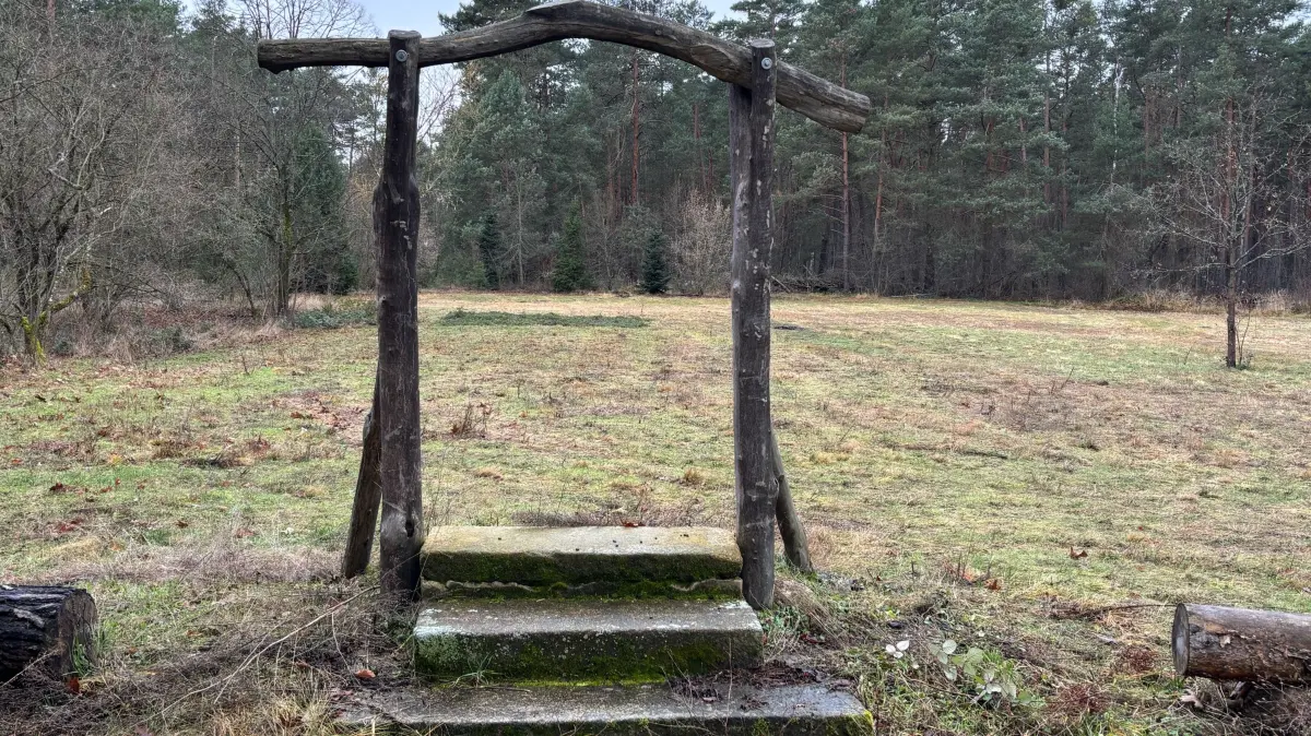 Diese drei Stufen samt symbolischer Eingangspforte sind am Rand einer Freifläche inmitten der Ruhlander Heide zu finden. Was hat es damit auf sich?