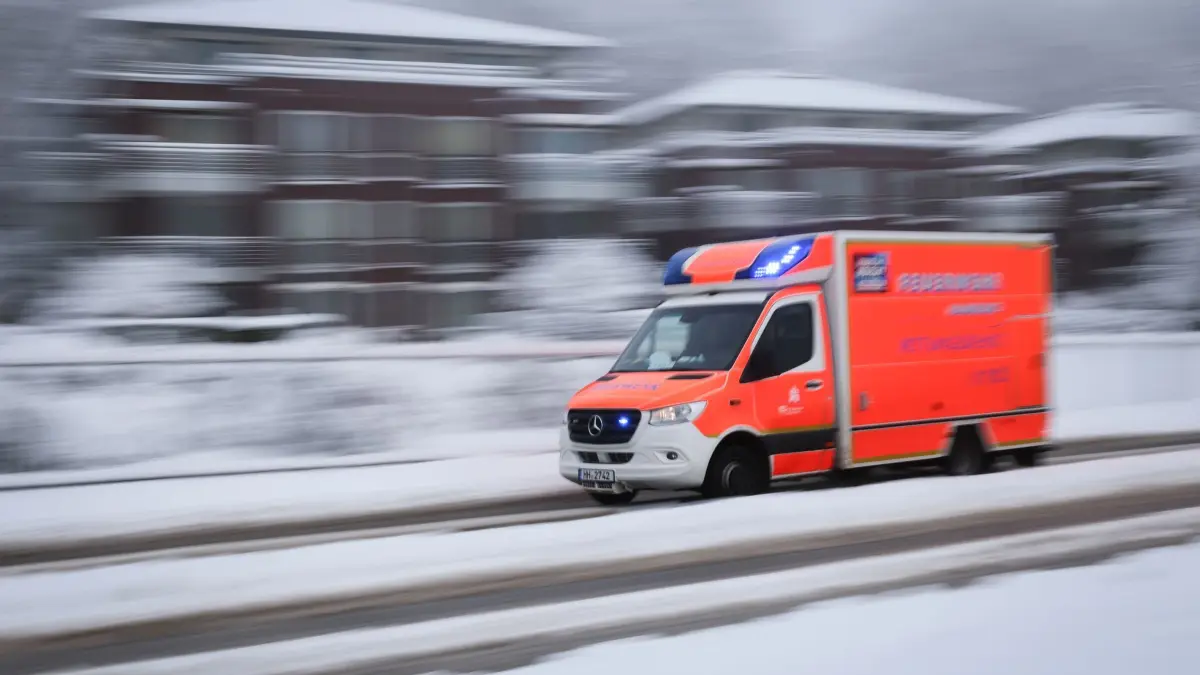 Schnee in Hamburg: 03.01.2026, Hamburg: Ein Rettungswagen der Feuerwehr ist auf der verschneiten Elbchausee auf dem Weg zu einem Einsatz. Foto: Christian Charisius/dpa +++ dpa-Bildfunk +++