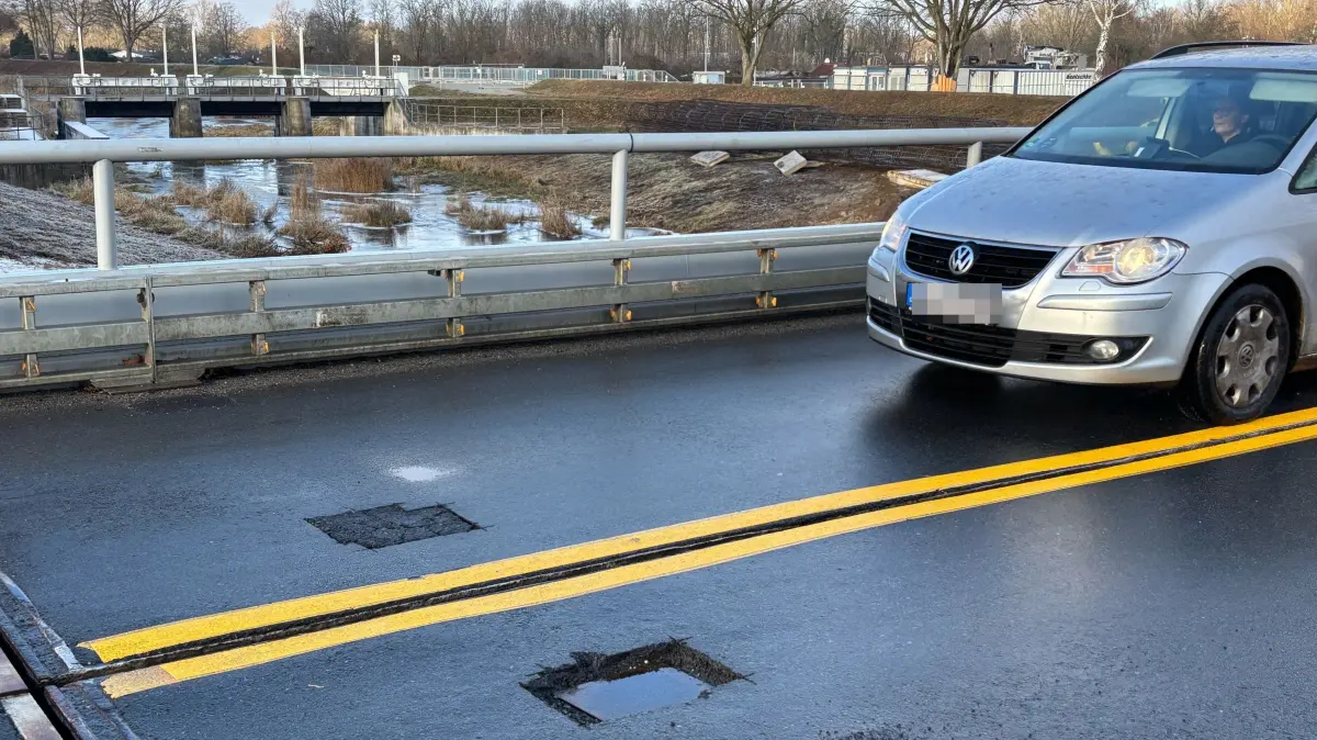 Ein Loch ist notdürftig verschlossen, ein weiteres steht offen. Wer über die Behelfsbrücke der B96 über die Schwarze Elster in Senftenberg fährt, sollte besondere Vorsicht walten lassen.