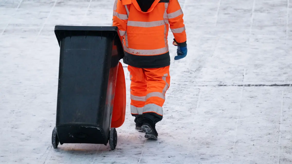 Schnee in Stuttgart: 07.01.2026, Baden-Württemberg, Stuttgart: Ein Mitarbeiter der Abfallwirtschaft zieht in der Innenstadt eine Mülltonne über einen verschneiten Weg. Foto: Marijan Murat/dpa +++ dpa-Bildfunk +++