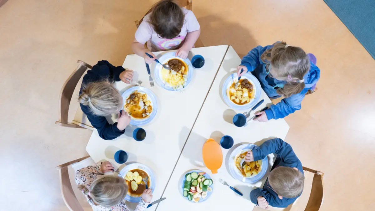 Kinder sitzen am Rande einer Pressekonferenz in einer Kindertagesstätte beim Mittagessen an einem Tisch. Anlass ist die Präsentation der Ergebnisse einer über vier Jahre währenden Studie zu Aspekten der Kindergesundheit. +++ dpa-Bildfunk +++