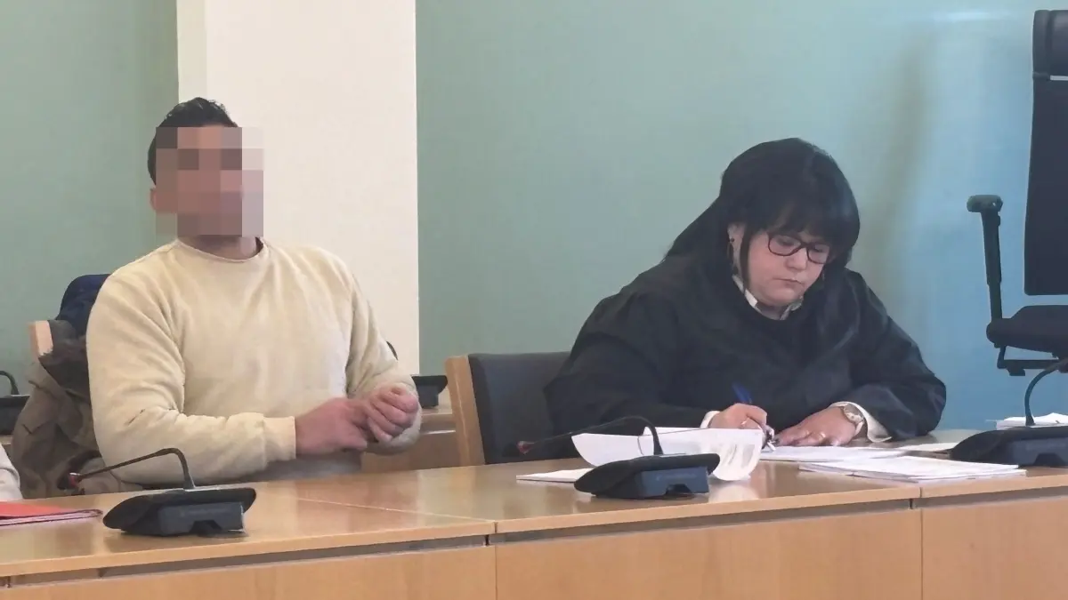 Landgericht Cottbus: Der Angeklagte (M.), hier mit seiner Verteidigerin (r.) und einem Übersetzer (l.) soll im Juli 2025 versucht haben, seinen Mitbewohner mit einem Messer zu töten. Sein Motiv gibt Rätsel auf.