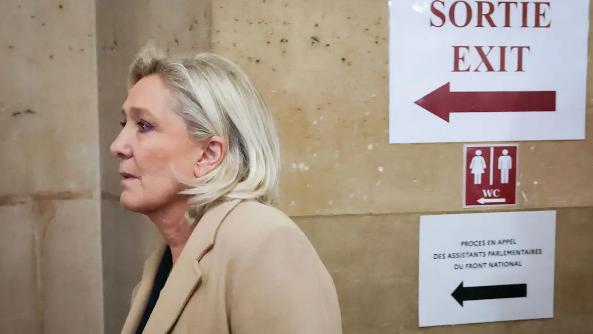 President of the parliamentary group of the French far-right Rassemblement National (RN) party, Marine Le Pen arrives for a hearing in her appeal trial on suspicion of embezzlement of European public funds, at Paris courthouse, on January 13, 2026. The appeal comes after a court last year barred the President of the RN parliamentary group Marine Le Pen from running for office for five years over a European Parliament fake-jobs scam involving her and other officials from her National Rally party. The hearing is expected to run until February 11, 2026, with a decision expected this summer. Twelve of the accused, as well as the far-right party itself, have appealed against the verdict while another 12 people -- including one of Le Pen's sisters -- have decided to accept their convictions without appealing. (Photo by Thomas SAMSON / AFP)