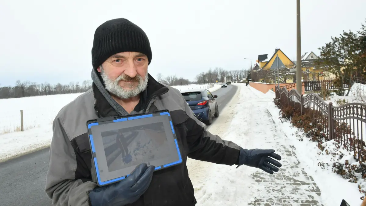Regelmäßig mehrmals mit Schneemassen zugeschüttet ist der Fußweg in der Stolzenhainer Straße in Prösen. Jörg Stein ist sauer und hat die Beweisfotos auf seinem Tablet.