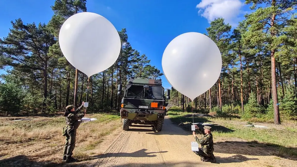Soldaten vom APV-Trupp (Abstandsfähige Produktverbringung) befestigen die vier Kilogramm schweren Pakete mit über 2000 Flugblättern am Ballon während einer Übung der Soldaten vom Zentrum für Operative Kommunikation auf dem Truppenübungsplatz Oberlausitz.