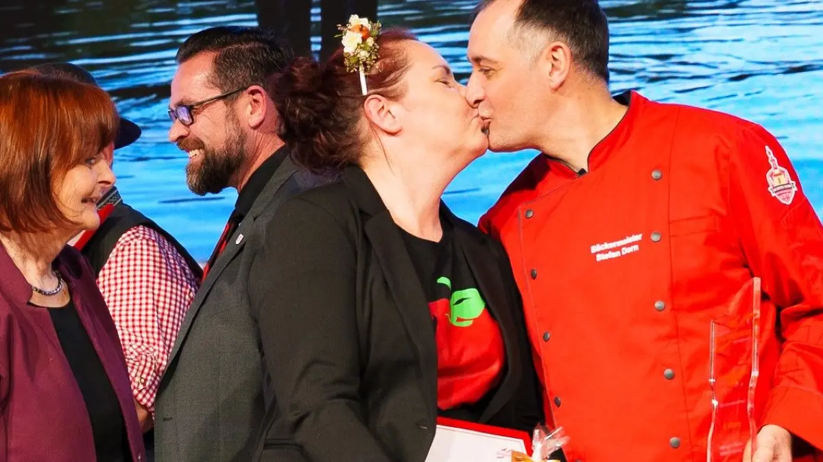 Ein Knutscher auf den Sieg und den 1. Preis in der Kategorie Direktvermarktung für den Niederlausitzer Apfelstollen. Daniela und Stefan Dorn von der gleichnamigen Bäckerei in Wahrenbrück auf großer Bühne in der Brandenburghalle während der Vergabe der Marketingpreise zur Grünen Woche.