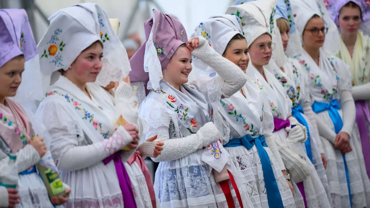 Wendische Fastnacht im Spreewald: 17.01.2026, Brandenburg, Burg (Spreewald): Junge Frauen in traditioneller wendischer Festtagstracht warten auf den Beginn des Umzuges. An der 133. Jugendfastnacht beteiligten sich rund 40 Paare. Mit der wendischen Fastnacht (Zapust) werden im Spreewald und der Niederlausitz die winterlichen Arbeiten in der Spinte (Spinnstube) beendet. Er ist der bekannteste und in den meisten Dörfern gefeierte Brauch. Neben dem Zampern gehört auch der Fastnachtsumzug dazu. Foto: Patrick Pleul/dpa +++ dpa-Bildfunk +++