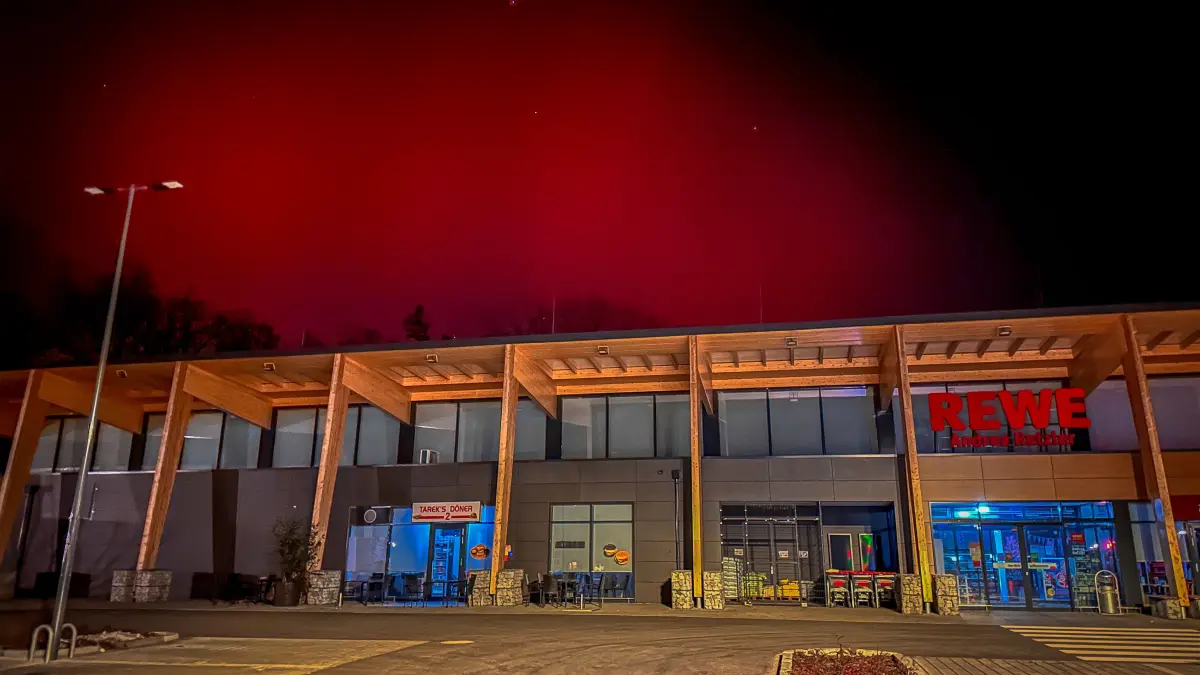Der Himmel über dem Rewe-Einkaufsmarkt im Wohngebiet Dichterviertel in Bad Liebenwerda. Polarlichter machen es möglich.