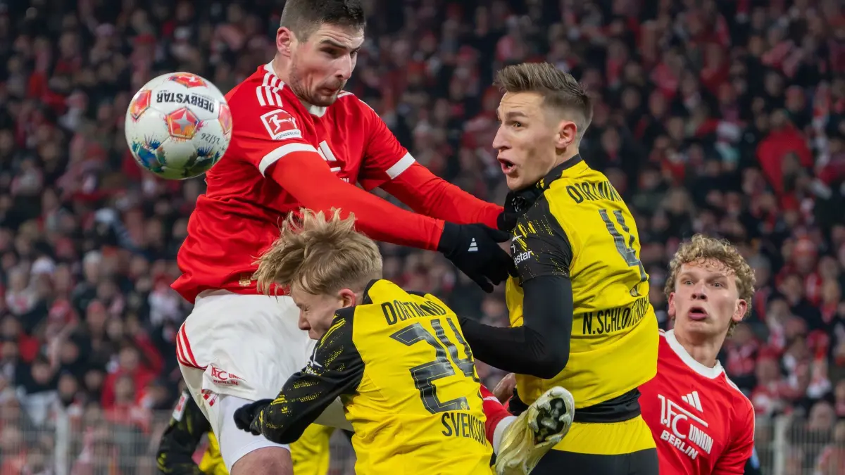1. FC Union Berlin - Borussia Dortmund: 24.01.2026, Berlin: Fußball: Bundesliga, 1. FC Union Berlin - Borussia Dortmund, 19. Spieltag, An der Alten Försterei, Andrej Ilić (1. FC Union Berlin) gegen Nico Schlotterbeck (Borussia Dortmund) und Daniel Svensson (M, Borussia Dortmund). Rechts steht Leopold Querfeld (1. FC Union Berlin). Foto: Soeren Stache/dpa - WICHTIGER HINWEIS: Gemäß den Vorgaben der DFL Deutsche Fußball Liga bzw. des DFB Deutscher Fußball-Bund ist es untersagt, in dem Stadion und/oder vom Spiel angefertigte Fotoaufnahmen in Form von Sequenzbildern und/oder videoähnlichen Fotostrecken zu verwerten bzw. verwerten zu lassen. +++ dpa-Bildfunk +++