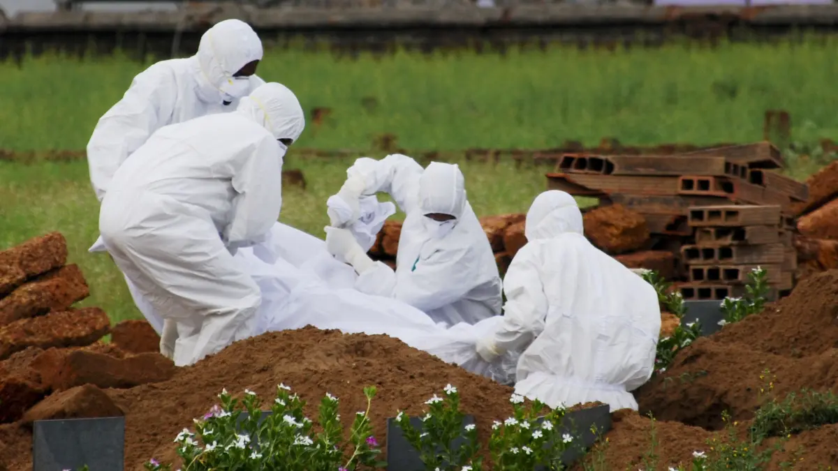 24.05.2018, Indien, Kozhikode: Rettungssanitäter in Schutzanzügen begraben ein Opfer, das aufgrund des Nipah-Virus verstarb. Beim Ausbruch des gefährlichen Nipah-Virus in Indien sind mehrere Menschen gestorben. Der Erreger kann bei Menschen Fieber, Atemwegserkrankungen und tödliche Hirnhautentzündungen verursachen. Es gibt weder eine Impfung noch eine wirkungsvolle Behandlung. Foto: K.Shijith/AP/dpa +++ dpa-Bildfunk +++