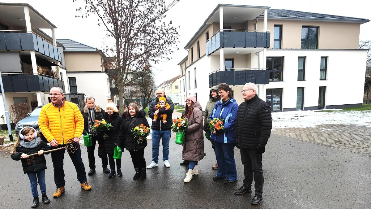 Geschäftsführer Steffen Markgraf (2.v.l.) begrüßt die neuen Mieter der Wohnungsgesellschaft im Quartier Bleichwiese. Den großen Schlüssel zum Neubau darf die sechsjährige Emilia (l.) übernehmen. Gast der Übergabe war Oberbürgermeister Torsten Ruban-Zeh (r.).