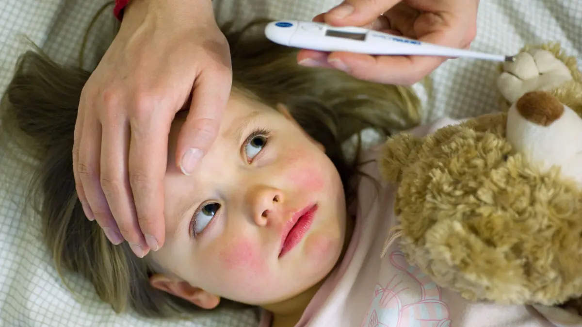 ARCHIV - Eine Mutter kontrolliert mit einem Fieberthermometer die Temperatur ihrer erkälteten dreijährigen Tochter Amy, aufgenommen am 15.04.2010 in Frankfurt (Oder). (zu dpa:"Zeitung: Krankmeldung wegen Kindern in zehn Jahren verdoppelt" vom 10.10.2017) Foto: Patrick Pleul/dpa +++ dpa-Bildfunk +++